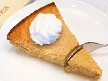 A fork cutting into the cheesecake.