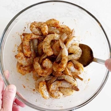 Mixing the shrimp with oil and spices.