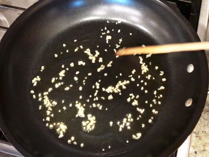 Cooking garlic in olive oil in a skillet.