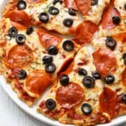 Chicken crust pizza is topped with olives.