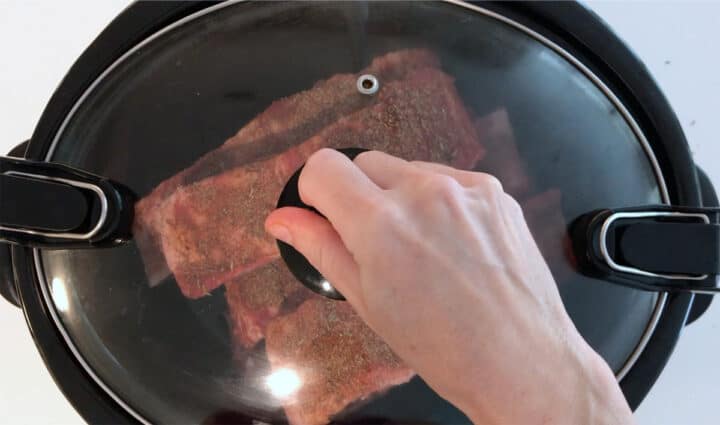 Covering the slow cooker.