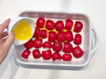 Adding melted butter to pan with radishes.