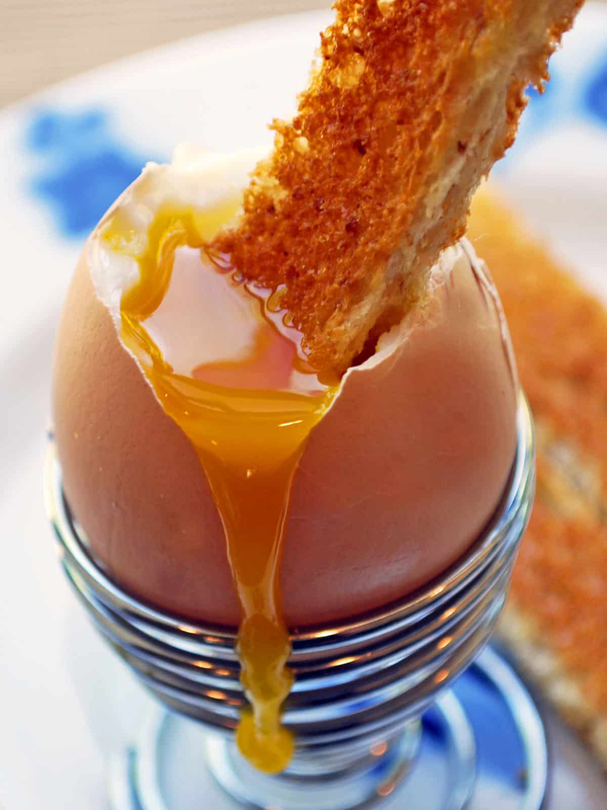 Toast is dipped into the thick yolk of a soft-boiled egg. 