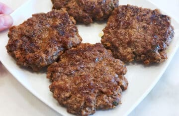 The burgers are served on a white plate.