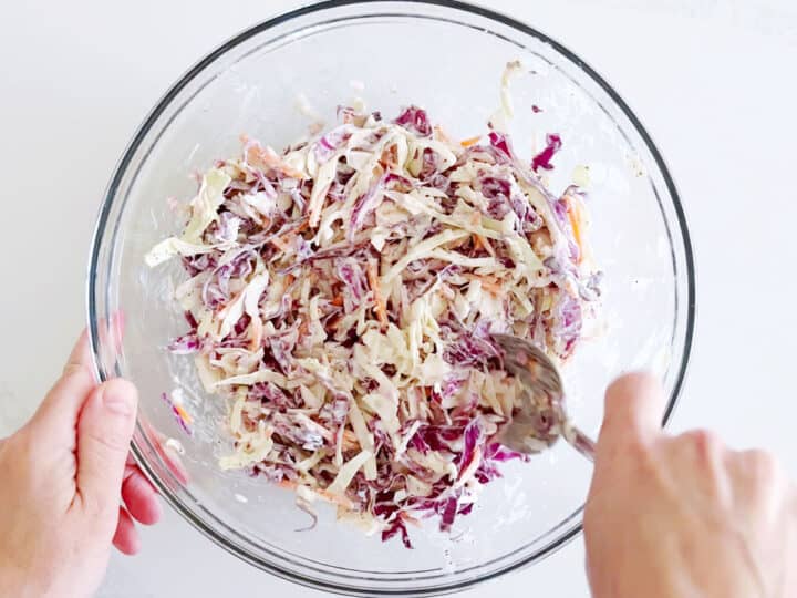 Mixing the cabbage and dressing for coleslaw.