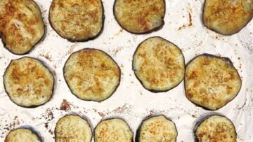 Baked eggplant slices on a baking sheet.