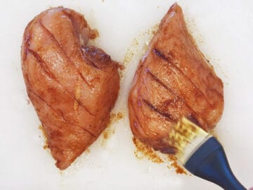 Brushing the chicken with the marinade.