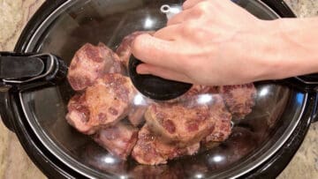 Closing the slow cooker lid.