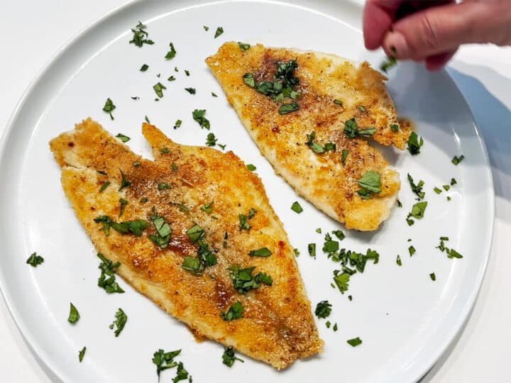 Garnishing the fish with parsley.