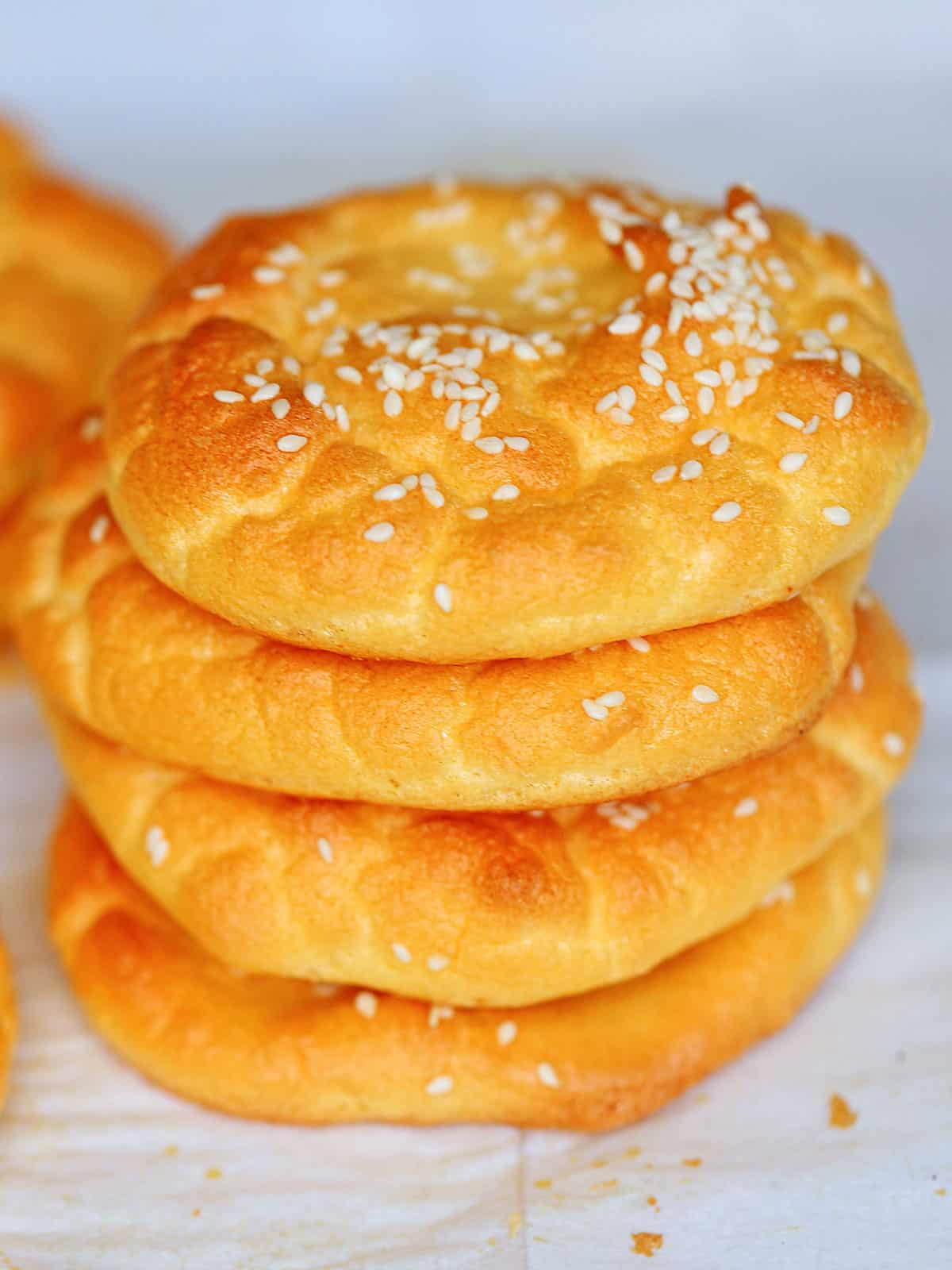 Four pieces of cloud bread are stacked on parchment paper.
