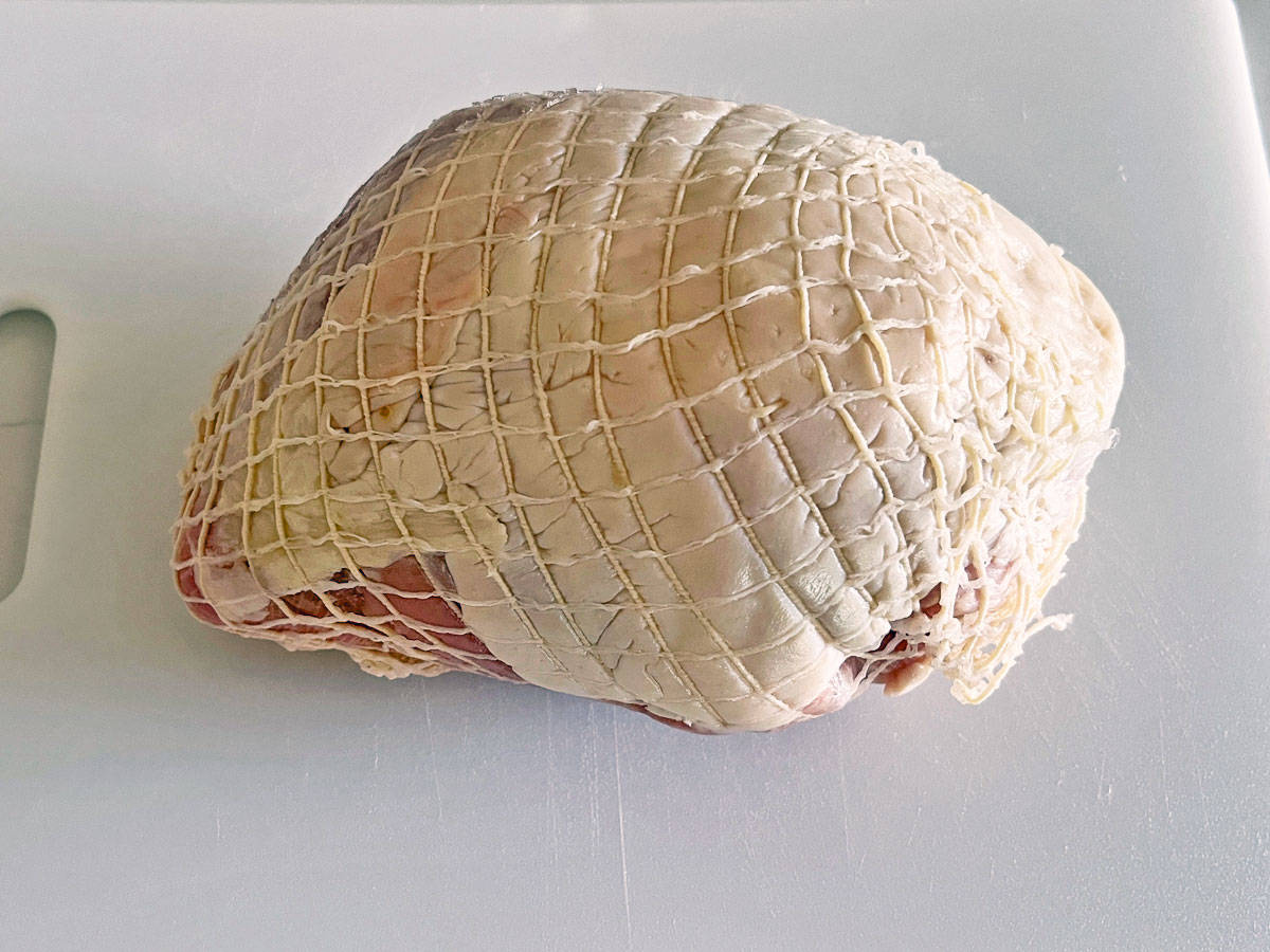 A whole turkey breast wrapped in netting.