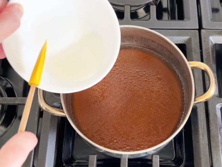 Adding cornstarch slurry to cooking liquids.