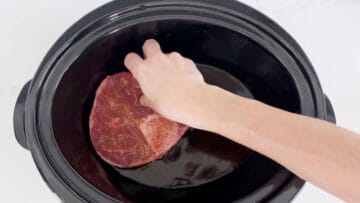 Placing the shanks in the slow cooker.