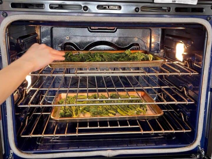 Placing the broccolini in the oven.