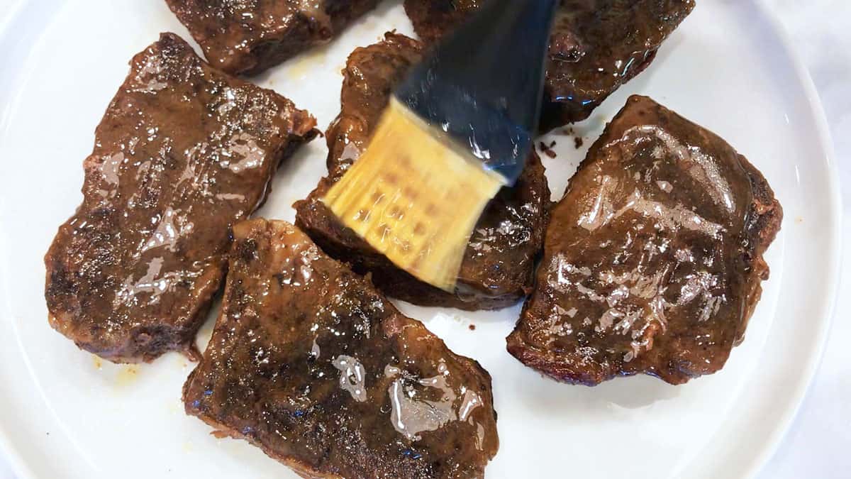 Brushing the ribs with the cooking liquids.