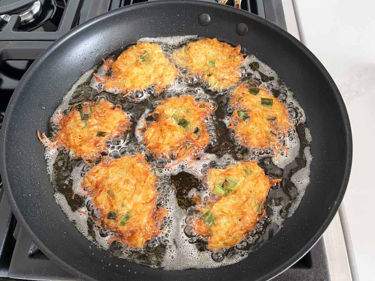 Nicely browned latkes in a skillet.