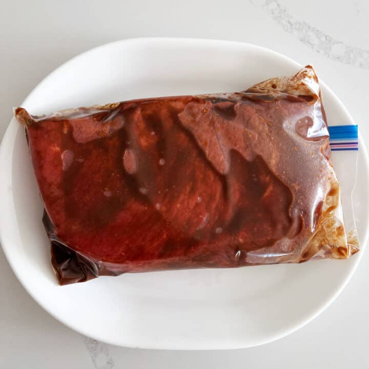 London broil steak is marinating in a Ziploc bag.