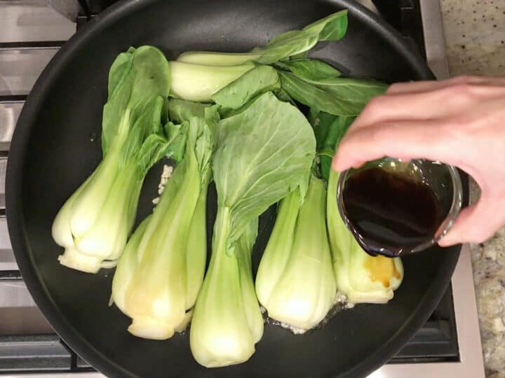 Adding soy sauce and vinegar to the skillet.