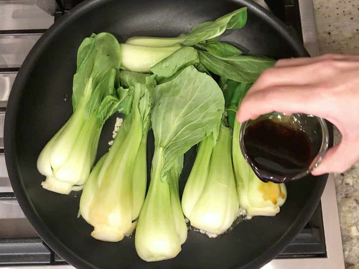 Adding soy sauce and vinegar to the skillet.