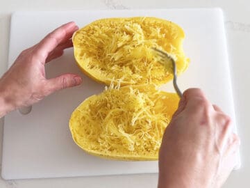 Raking a fork back and forth to create spaghetti squash strands.