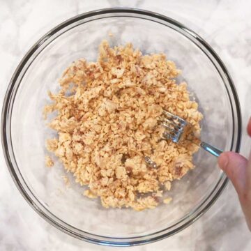 Flaking the salmon in a bowl.