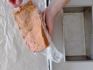 Inverting the shaped meatloaf onto the baking sheet.