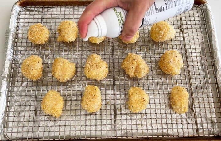 Spraying the scallops with oil.