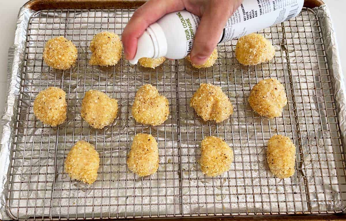 Spraying the scallops with oil.