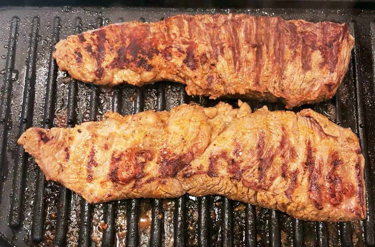 Grilling the steak on the second side.