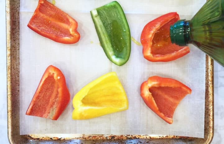 Adding olive oil to the peppers.