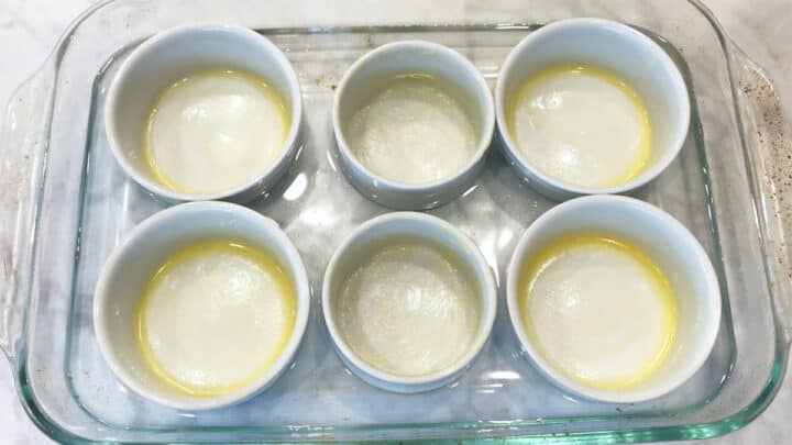 Buttered ramekins in a water bath.