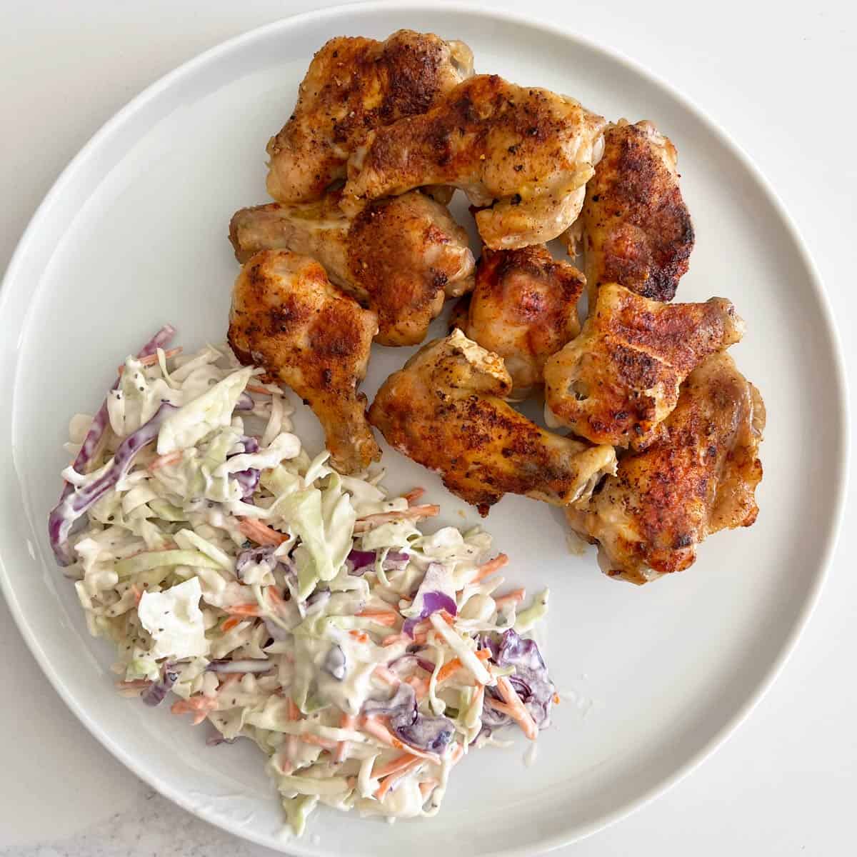 Baked wings are served with coleslaw.