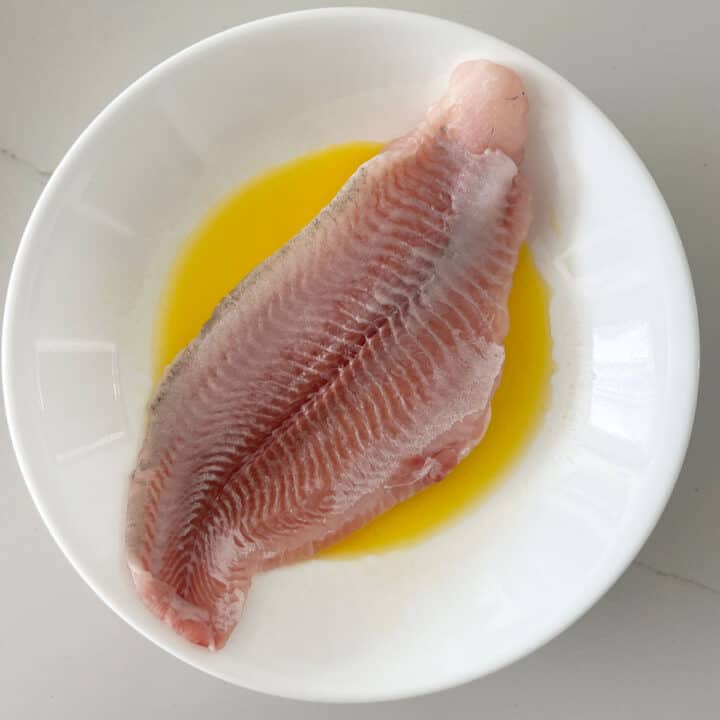 Dipping the fish in melted butter.