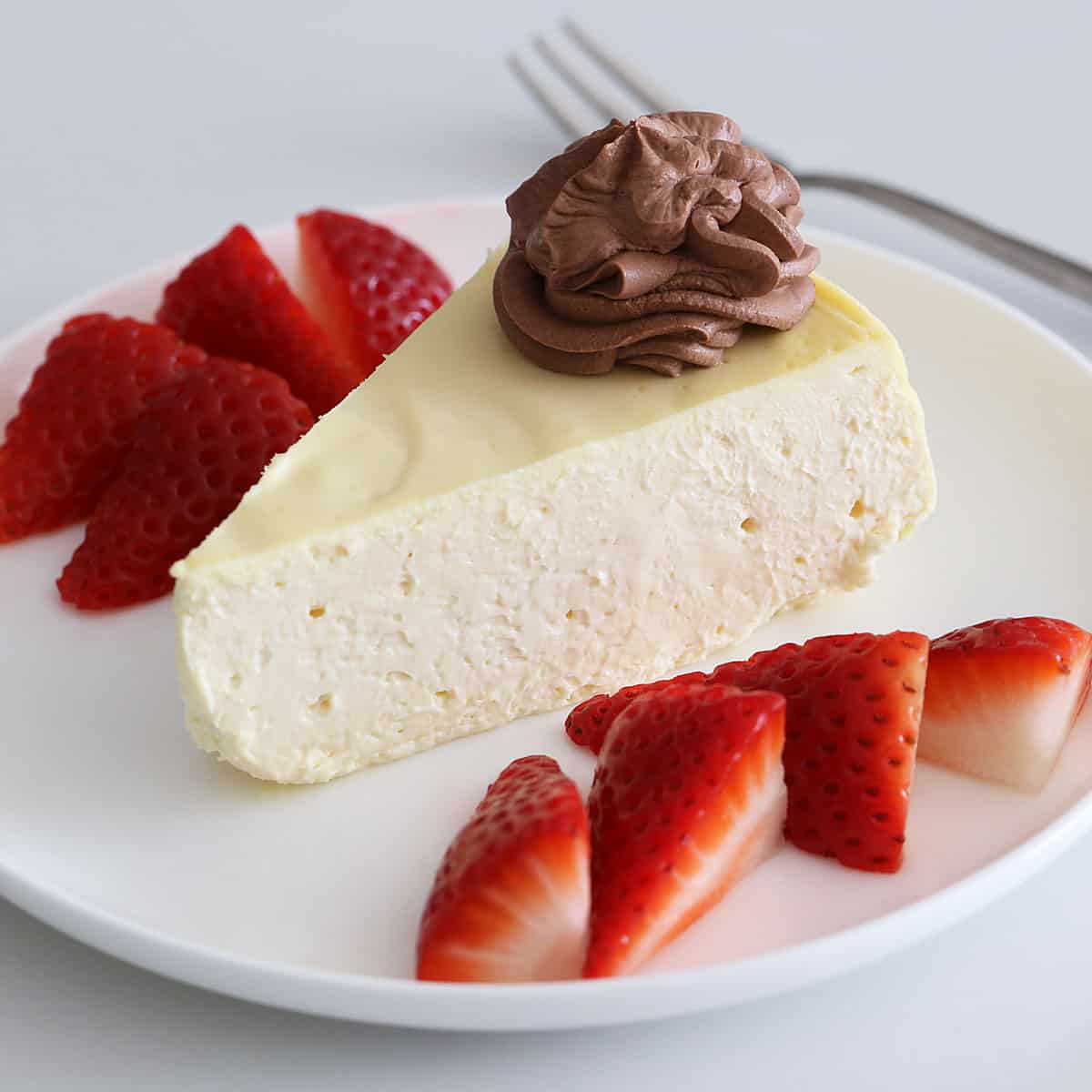 A slice of keto cheesecake topped with chocolate mousse.