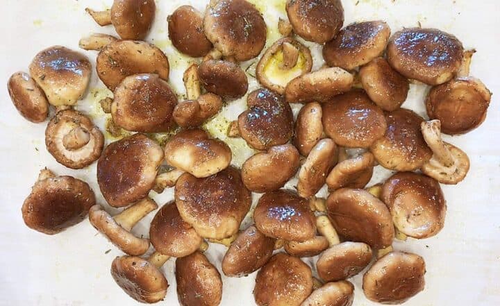 Arranging the coated mushrooms on the baking sheet.