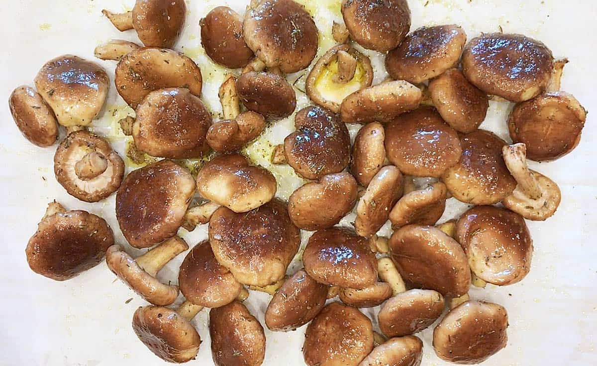 Arranging the coated mushrooms on the baking sheet.