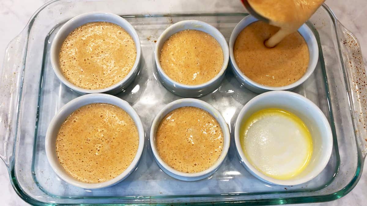 Pouring the souffle mixture into the ramekins.