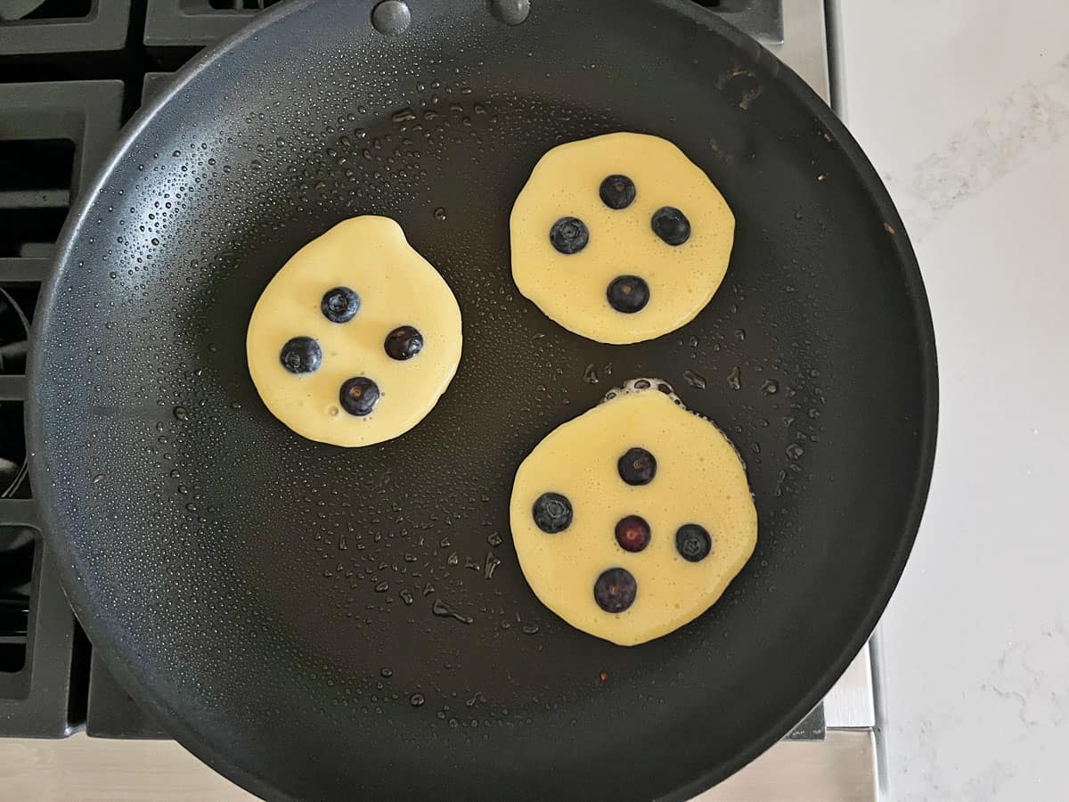 Blueberry protein pancakes in a skillet.