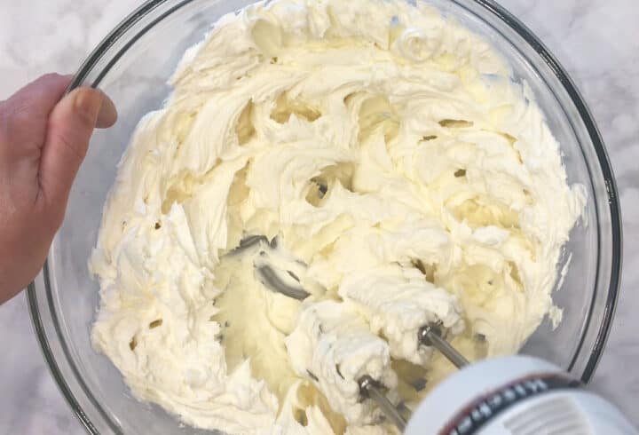 Whipping the cream cheese.
