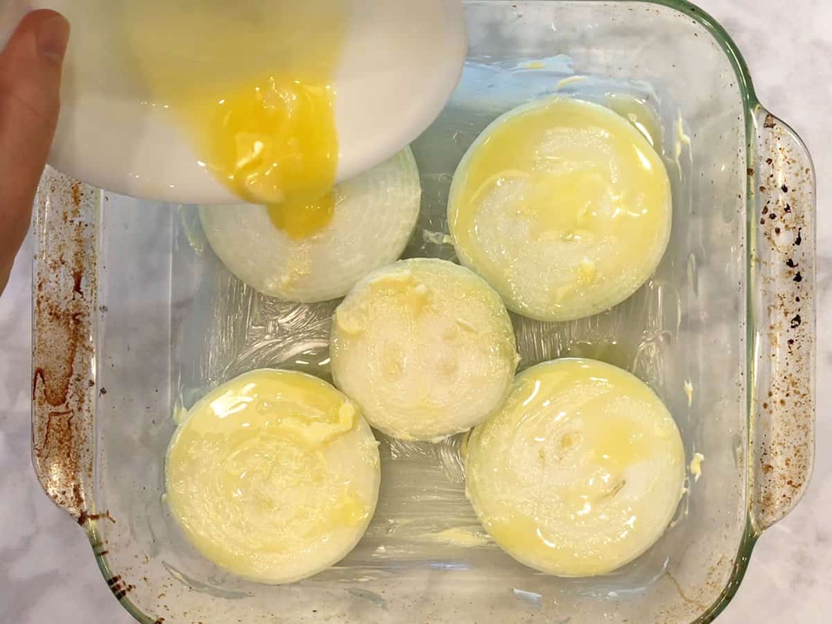 Pouring melted butter on the onions.