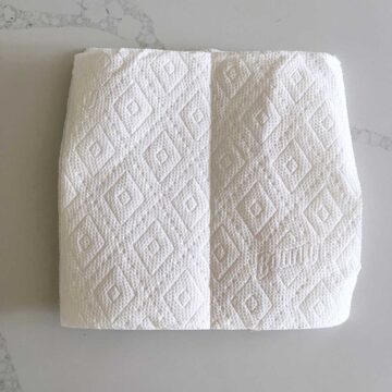 The bacon is covered with paper towels.