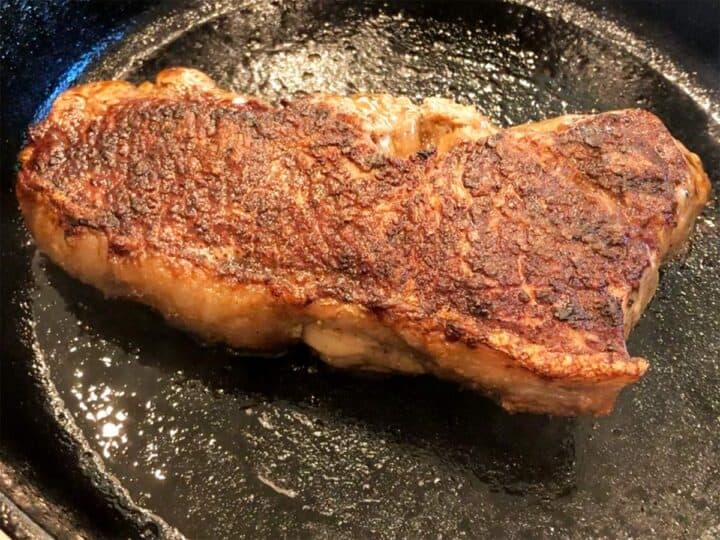 The steak is ready in the skillet.