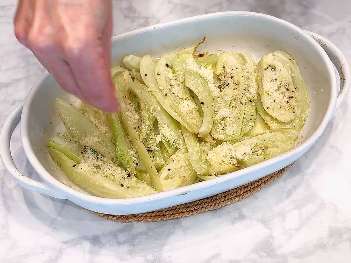 Sprinkling grated parmesan on top of the fennel.