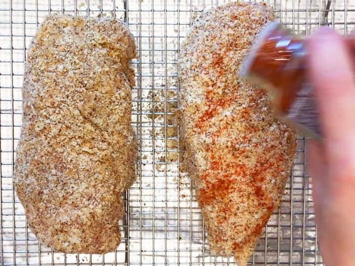 Sprinkling the chicken with paprika.