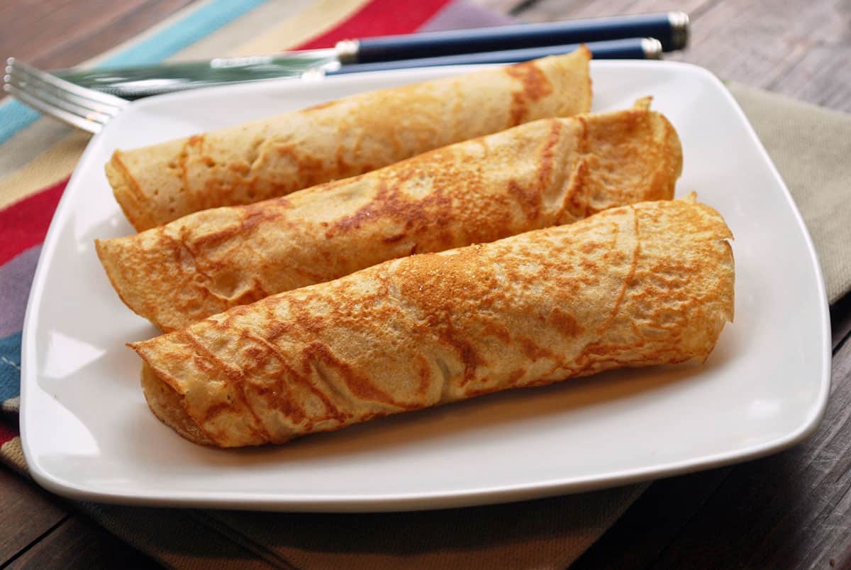 Three whole-wheat pannenkoeken on a plate.