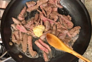 Adding garlic and ginger to the skillet.