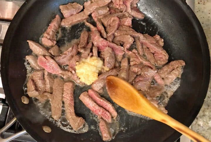 Adding garlic and ginger to the skillet.