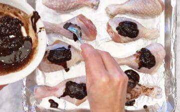 Coating the chicken in jerk seasoning.