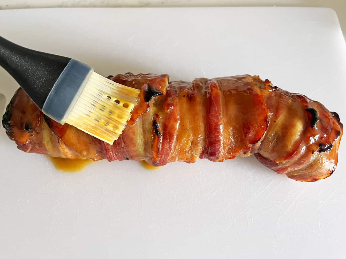 Brushing the fully cooked tenderloin with more sauce.