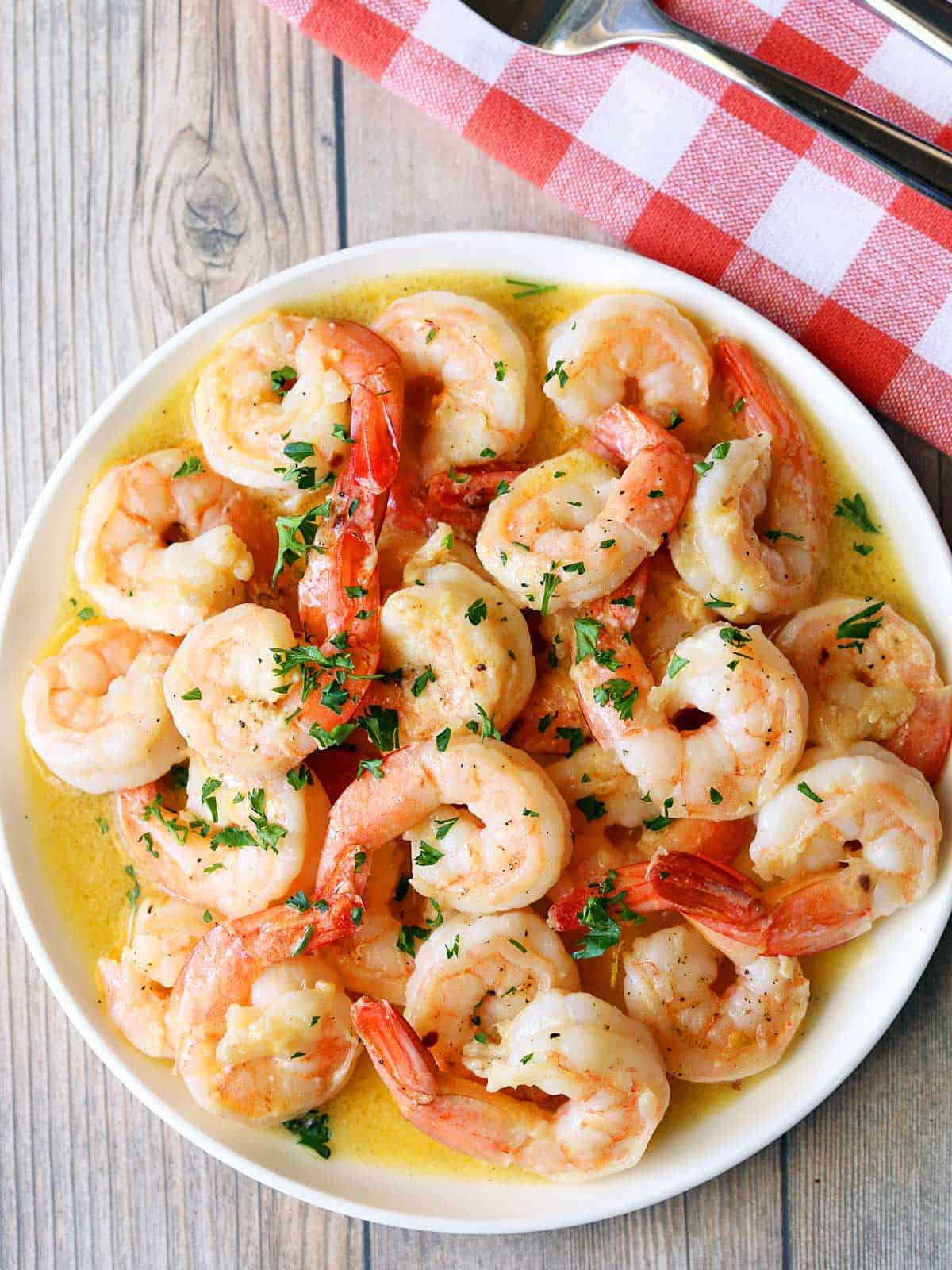 Shrimp scampi is served on a white plate.